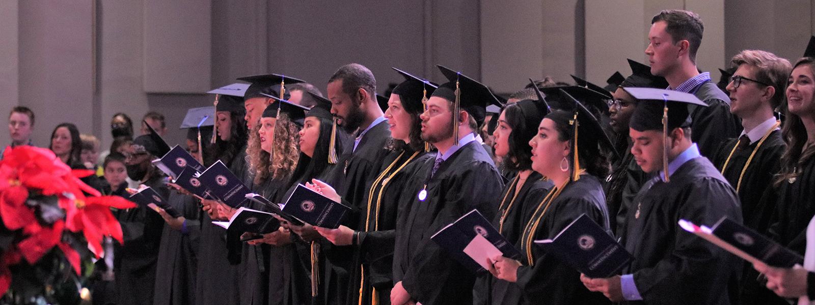 Graduates sing Christmas carols at the December commencement.