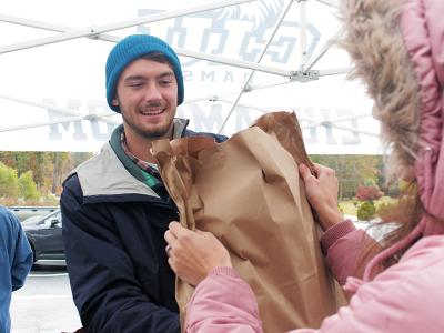 Chandler Sims offers a smile and a bag of groceries to a local resident.