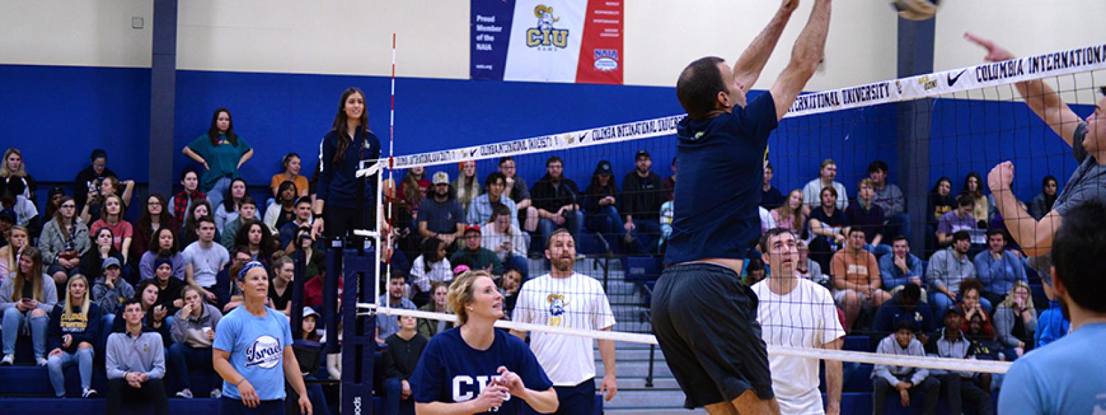 CIU Athletics Director James Whitaker attempts to block a shot at the Faculty/Staff Volleyball Match.
