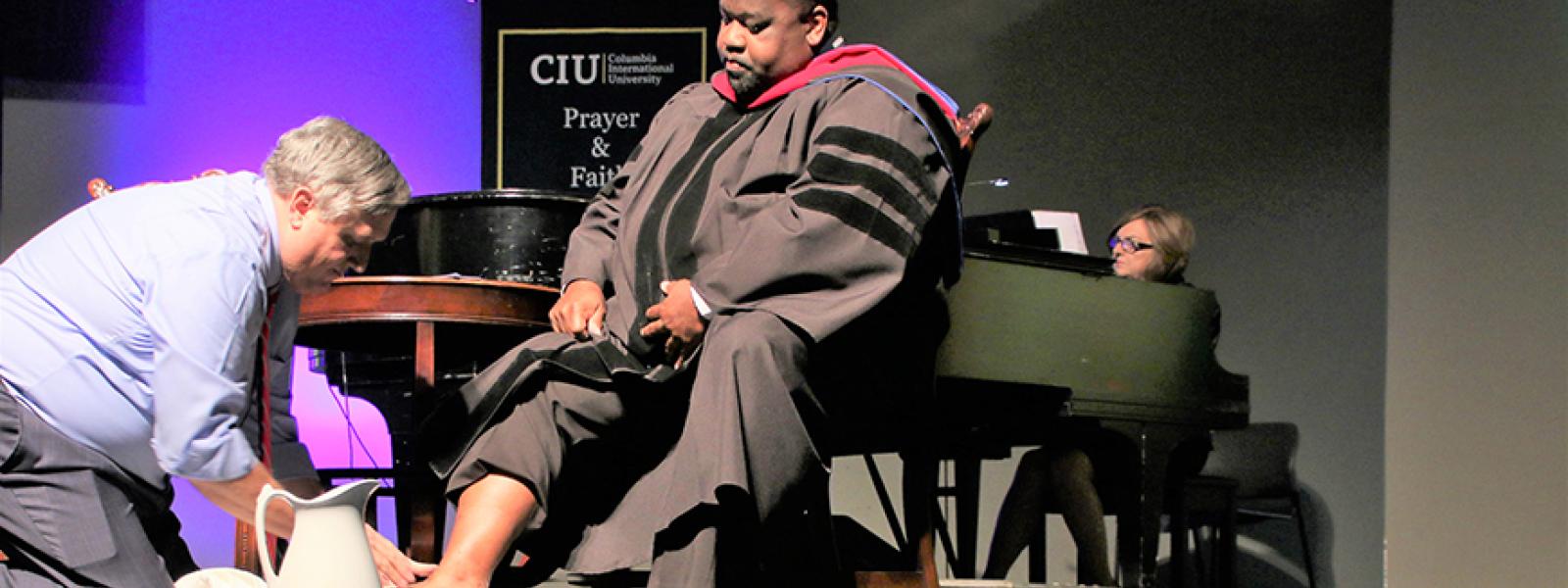 CIU President Dr. Mark Smith washes the feet of CIU Professor Dr. Andre Rogers at CIU's 2019 Convocation