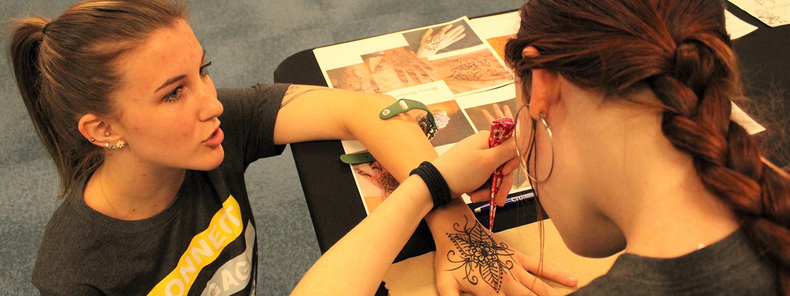CIU student Lena Ryberg is the recipient of the henna artwork of fellow student Christina Lambert. (Photo by Andrea Calamaro, CIU student photographer)