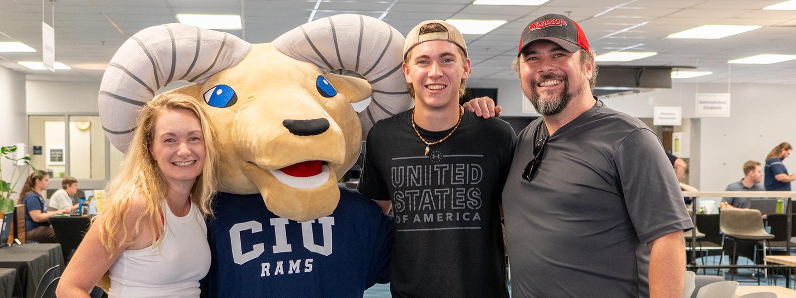 CIU alumni Jenita and Tim Pace pose with their son, CIU freshman Carter Pace, and CIU mascot Rammy. (Photo by Noah Allard)