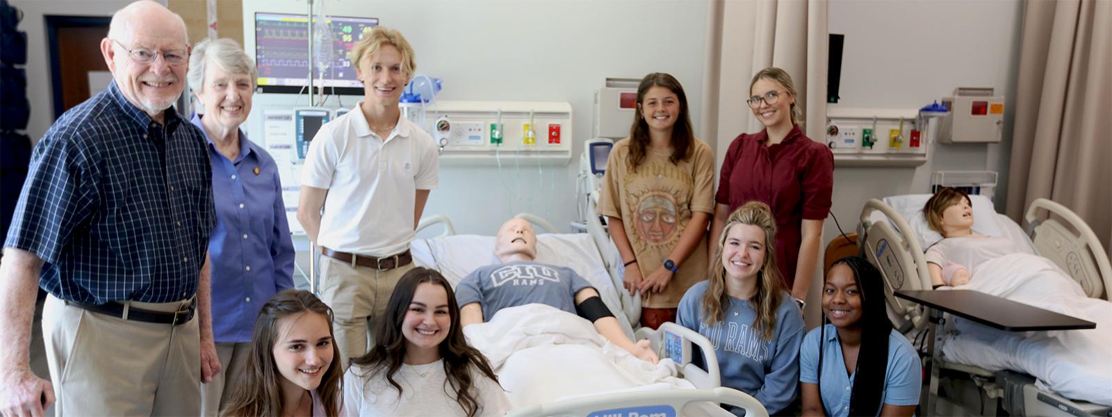 Dr. Johnny Miller and his wife Jeanne pose with CIU nursing students in the Jeanne Miller Simulation Center