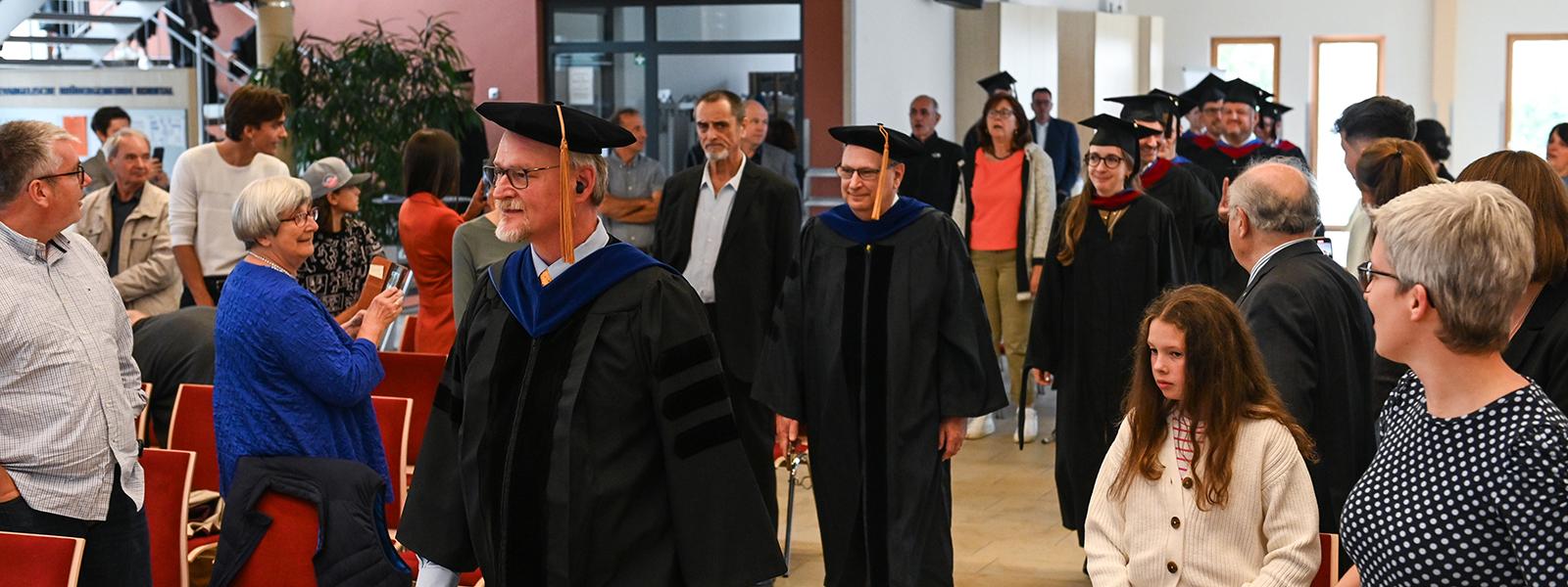 CIU Interim President Dr. Rick Christman (left) and Provost Dr. James Lanpher lead the commencement procession in Korntal.
