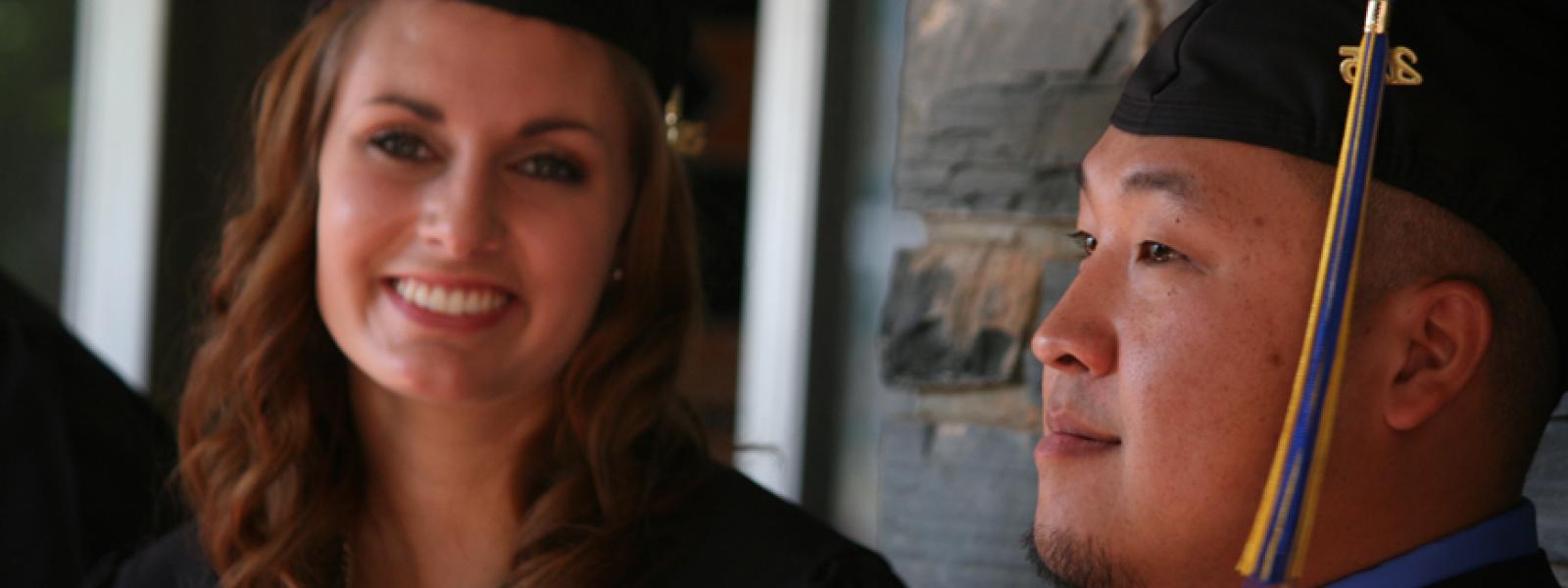 A photo of two 2015 CIU graduates. Donor scholarships allow students graduate with less debt.