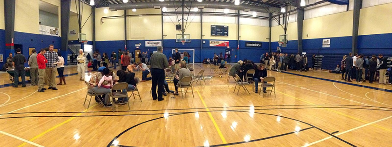 A photo of students, faculty and staff praying in the gym during Prayer Day at CIU.