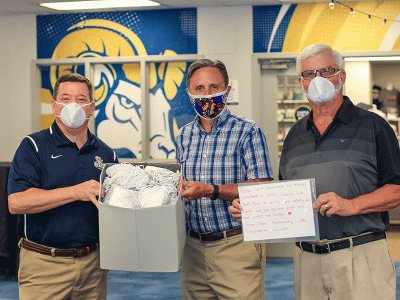 CIU Dean of Students Rick Swift (left) receives face masks from CIU alumni Robbie McAlister and Michael Johnson.