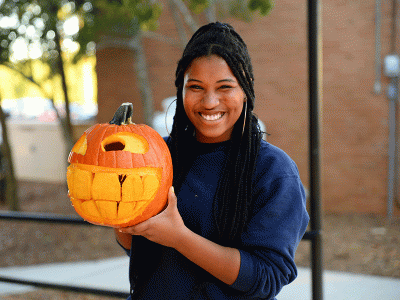 Joy Jones shares smiles with her jack-o-lantern. (Photos by Nathaniel Rabon, CIU Student Photographer)