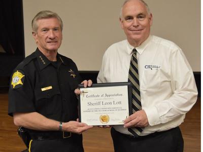 Sheriff Leon Lott accepting a certificate of appreciation from Scott Adams, dean of the School of Business
