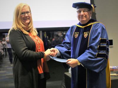 Patricia England receiving her Diploma in Women's Leadership from Provost Dr. James Lanpher