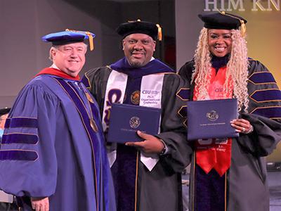 Aaron and Jennifer Bishop are congratulated by CIU President Dr. Mark a. Smith.