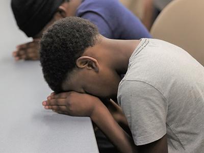 Hoop for Hope campers bow in prayer during a devotional session.  