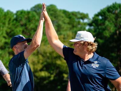 Bryson McDonald (left) and Wyatt Butcher, members of the CIU Rams golf team, celebrate. (Photo by Noah Allard)